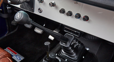 Manual stick shift and control knobs on white dashboard of Classic Ford Bronco