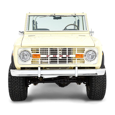 Front view of yellow Classic Ford Bronco featuring chrome bumper and round headlights on white background