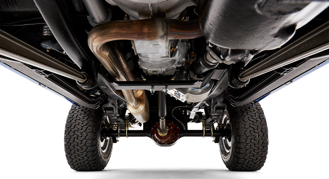 Close up undercarriage view showing exhaust pipes, differential, and suspension components of Classic Ford Bronco
