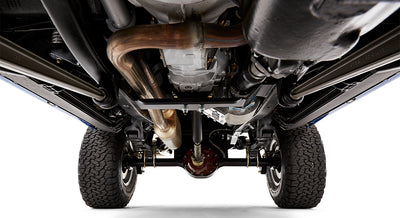 Close up undercarriage view showing exhaust pipes, differential, and suspension components of Classic Ford Bronco