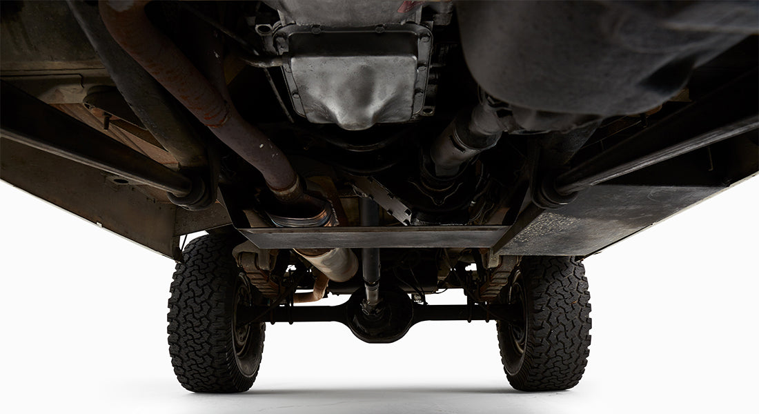 Close-up undercarriage view of green Classic Ford Bronco showing exhaust and drivetrain