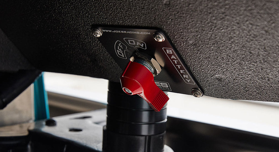 Red switch labeled battery on textured black panel with www.joebaracing.com text above switch