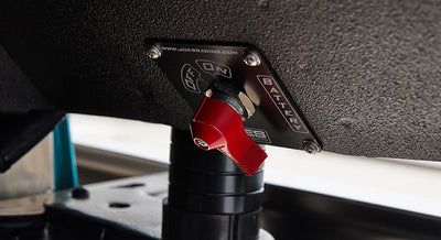 Red switch labeled battery on textured black panel with www.joebaracing.com text above switch