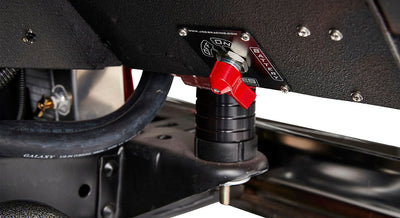 Red battery switch mounted on a metal surface with visible cables