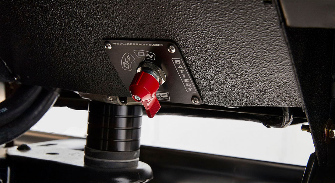 Red battery switch toggle mounted on a black panel inside Classic Ford Bronco