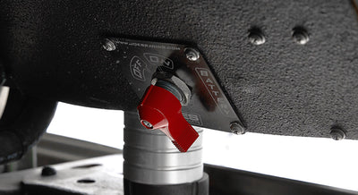 Red toggle battery switch mounted under the Classic Ford Bronco dashboard on a textured black surface.