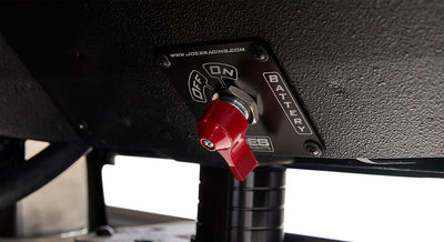 Red battery switch labeled ON and OFF mounted under dashboard