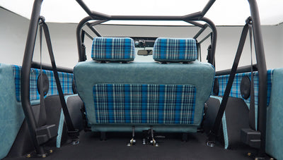 Interior rear seat and side panels of a Classic Ford Bronco in light blue leather and blue plaid fabric