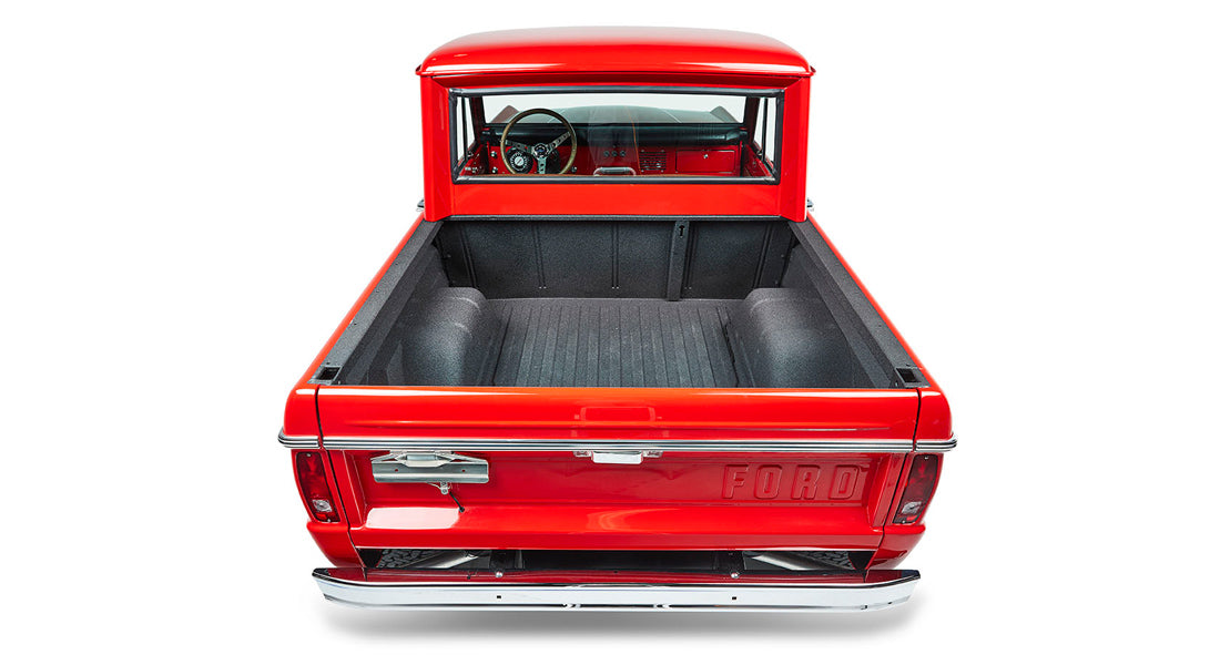 Empty red Classic Ford Bronco truck bed with FORD embossed on tailgate