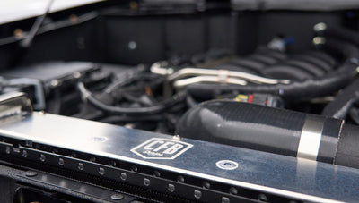 Close-up of engine components inside a Classic Ford Bronco including CFB branded parts and black hoses