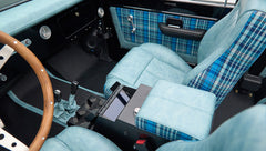 Interior view of Classic Ford Bronco front seats and center console in light blue leather and blue plaid
