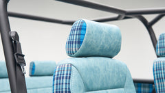 Close-up of light blue leather and blue plaid fabric on a Classic Ford Bronco seat headrest