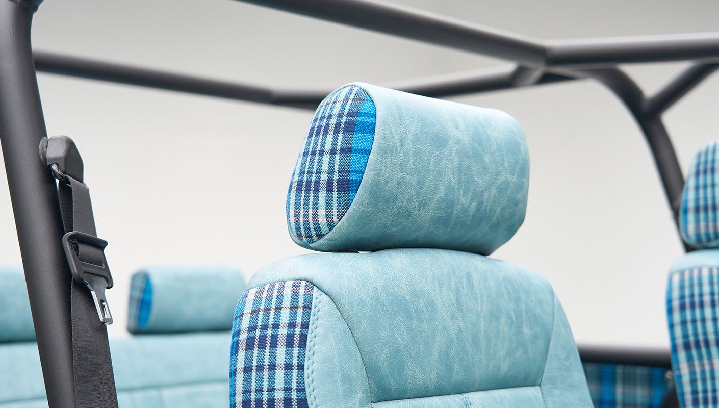 Close-up of light blue leather and blue plaid fabric on a Classic Ford Bronco seat headrest