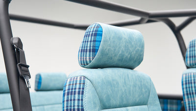 Close-up of light blue leather and blue plaid fabric on a Classic Ford Bronco seat headrest