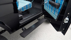 Side open door of Classic Ford Bronco showing black exterior and blue plaid interior seats