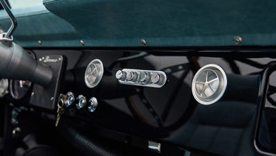 Close-up of Classic Ford Bronco dashboard with black glossy panel and round air vents