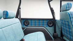 Rear interior view of Classic Ford Bronco showing blue plaid fabric seats and black roll cage