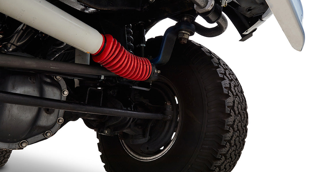 Close-up of rear suspension coil spring and tire of a Classic Ford Bronco with red protective cover