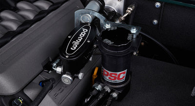 Close-up of Wilwood brake master cylinder and PSC power steering reservoir in Classic Ford Bronco engine bay