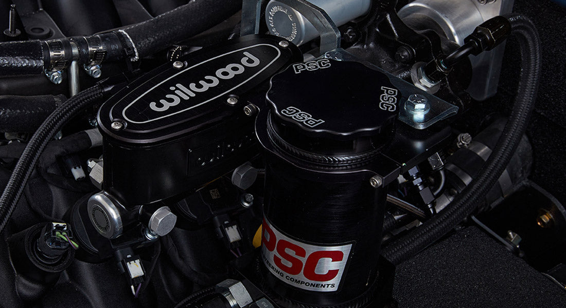 Close-up of black Wilwood brake assembly and PSC steering components in a Classic Ford Bronco engine bay