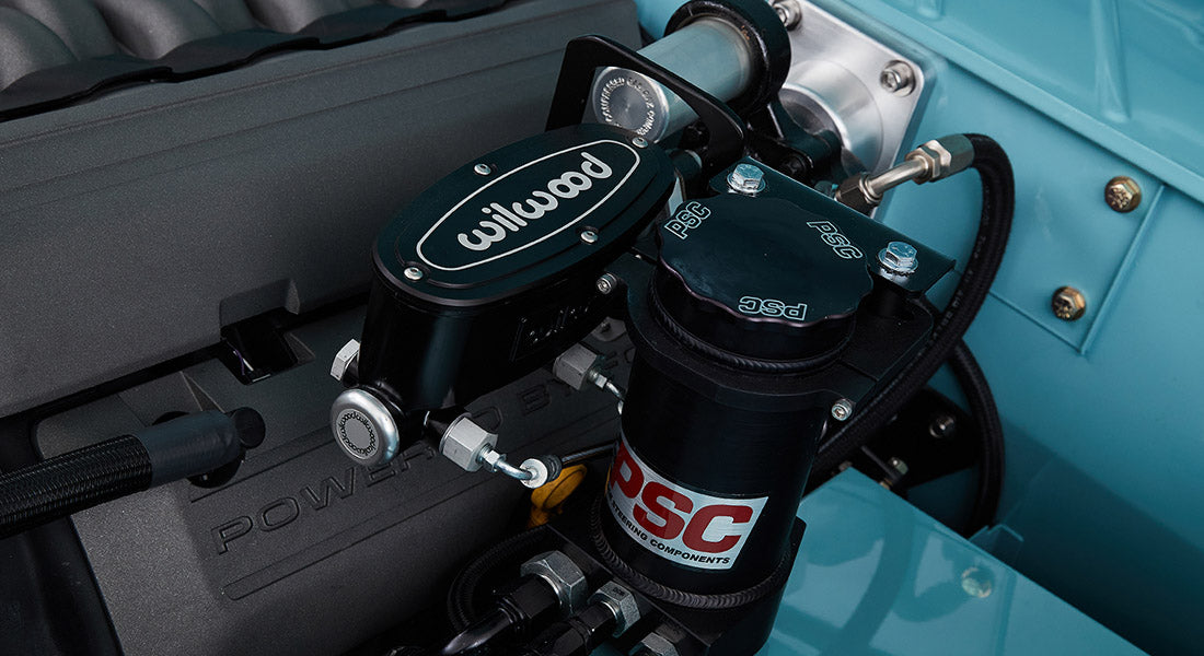 Detailed close-up of black and blue Wilwood brake assembly components inside engine bay