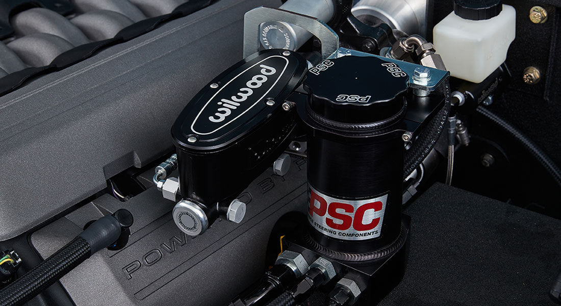 Close-up of black Wilwood and PSC power steering components in a Classic Ford Bronco engine bay