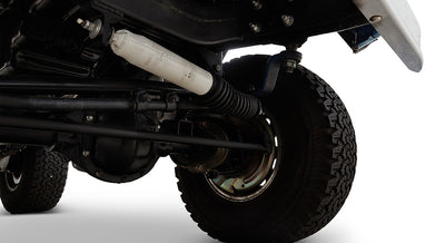Close-up of Classic Ford Bronco front suspension and steering components with tire.