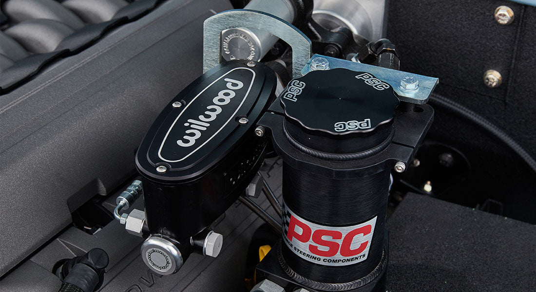 Close-up of Wilwood brake master cylinder and PSC power steering reservoir on Classic Ford Bronco engine