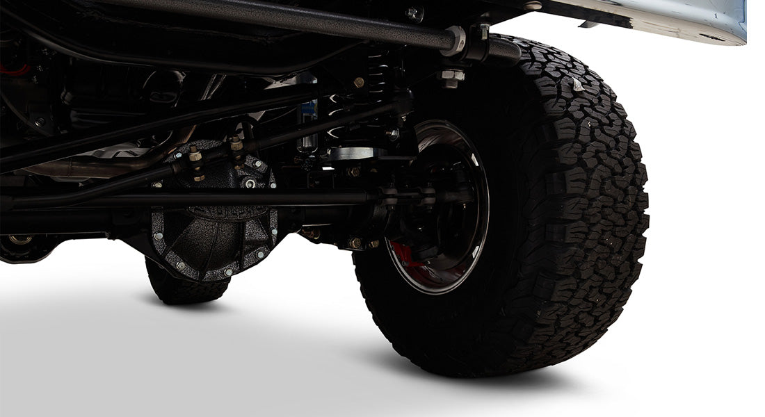 Classic Ford Bronco underside view showing suspension and large off-road tire