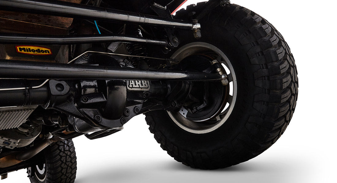 Close-up of rear axle and brake assembly on Classic Ford Bronco showing suspension and tire tread.