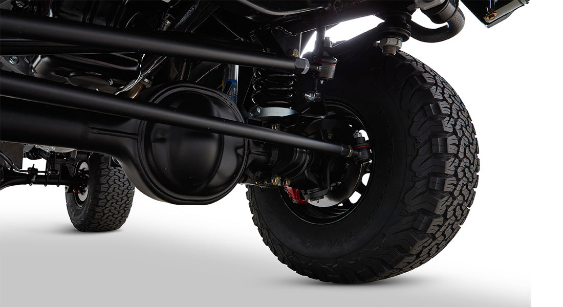 Rear suspension, axle, and tire view of Classic Ford Bronco on white background
