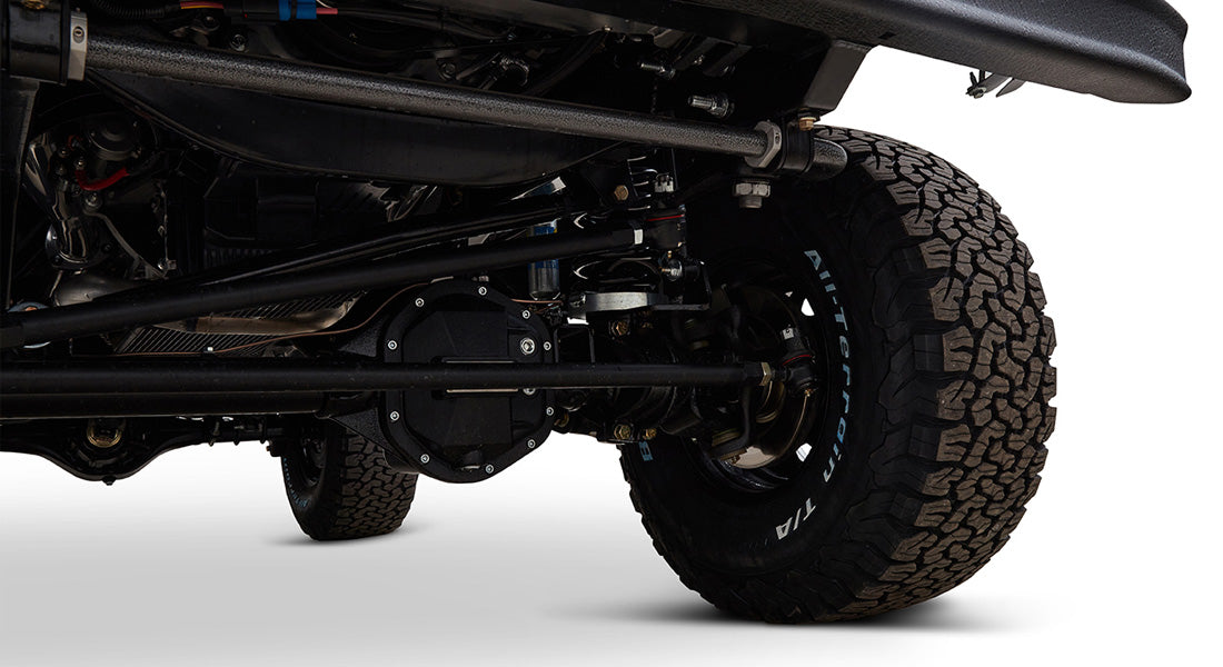 Detailed underneath view focusing on tires, axle, and suspension components of a Classic Ford Bronco