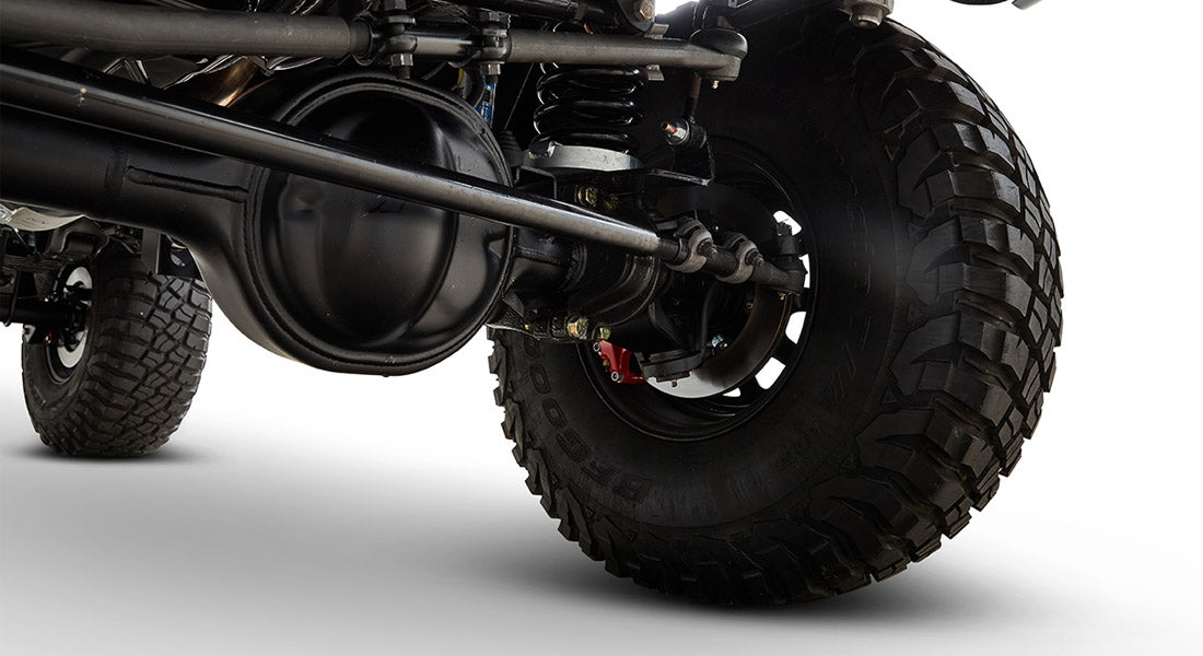Close-up of front suspension and large off-road tire on a Classic Ford Bronco