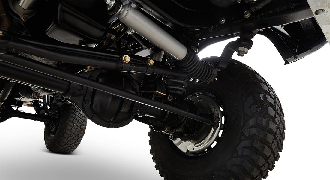 Undercarriage front axle and suspension components of a Classic Ford Bronco with rugged tire