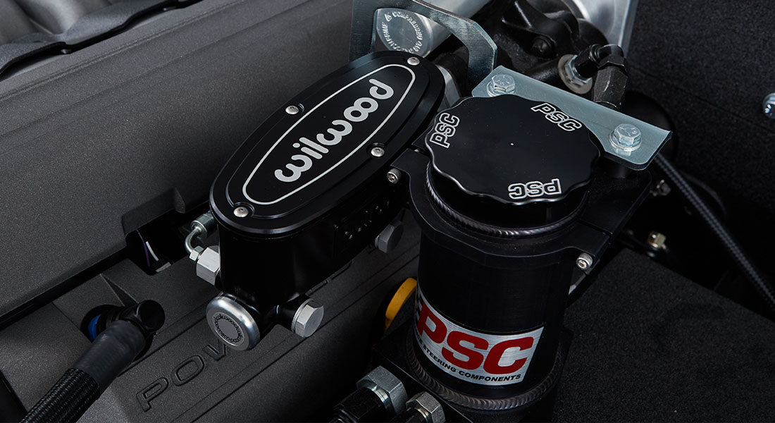 Wilwood brake fluid reservoir and PSC power steering component in engine bay of a Classic Ford Bronco.
