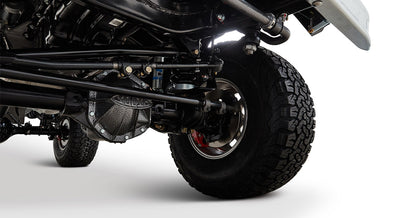 Classic Ford Bronco brake system and front axle visible above a tire against white background