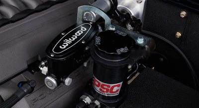 Close-up of power steering components including a reservoir marked PSC and Wilwood part