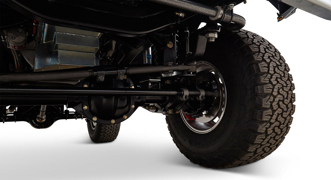 Underside view showing classic Ford Bronco's brake components and front suspension with off-road tire