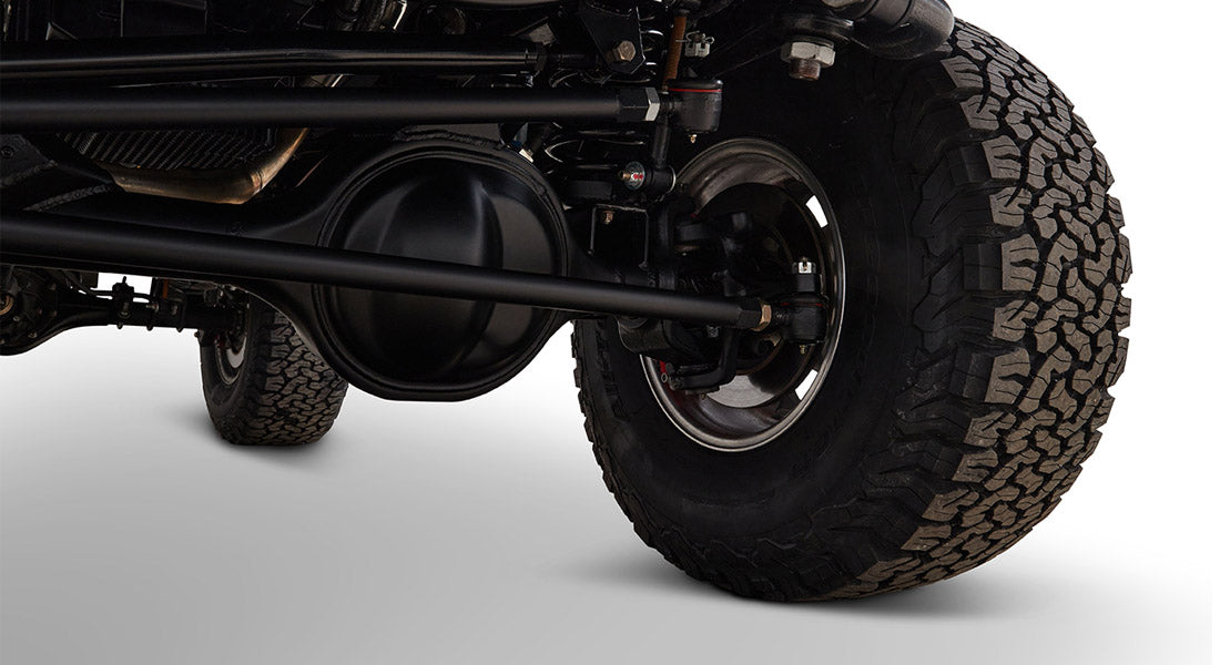 Undercarriage view showing axle, suspension, and tire of Classic Ford Bronco