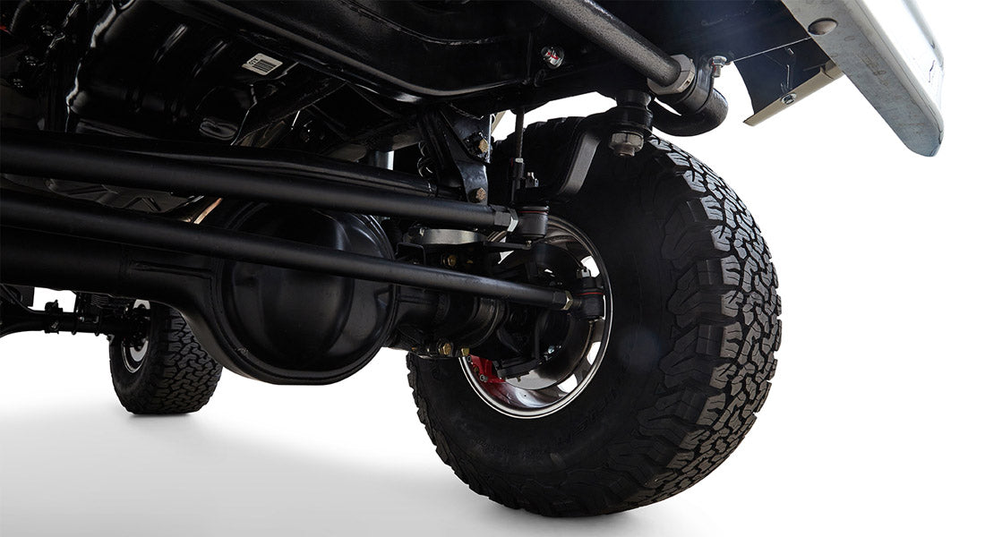 Underbody shot showing black suspension and large off-road tire on Classic Ford Bronco