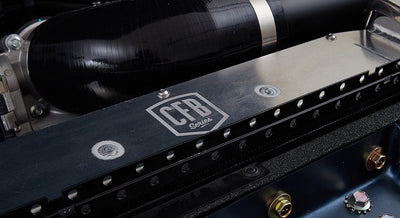 Close-up of black metal component with 'CFB Series' logo and mechanical parts inside a Classic Ford Bronco