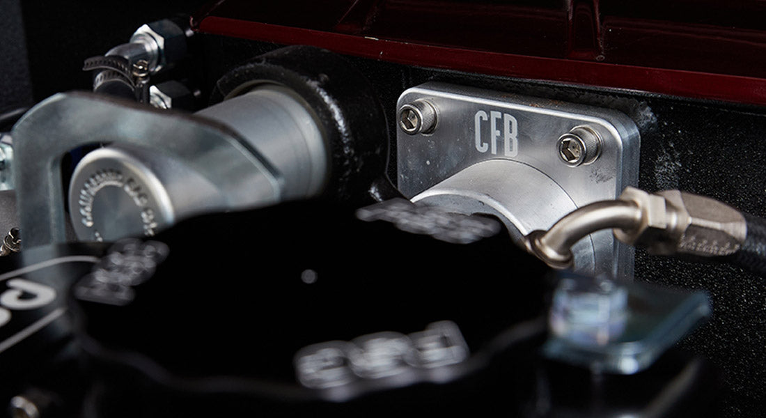 Close-up of black engine parts with CFB logo and hardware in Classic Ford Bronco