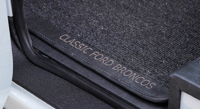 Close-up of floormat with text 'CLASSIC FORD BRONCOS' at vehicle door sill