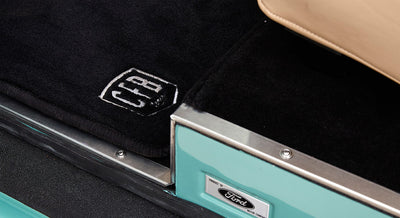 Interior door sill area of Classic Ford Bronco featuring black carpet with CFB logo and Ford Motor Company plaque