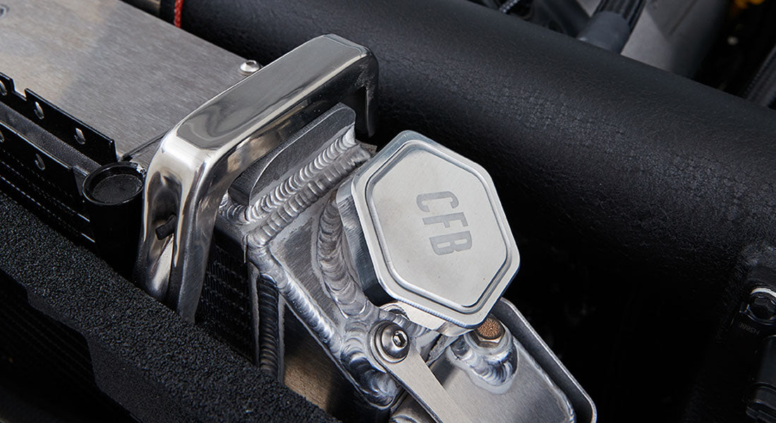 Metal engine coolant reservoir cap with CFB engraved, mounted in Classic Ford Bronco engine bay