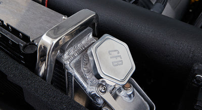 Metal engine coolant reservoir cap with CFB engraved, mounted in Classic Ford Bronco engine bay