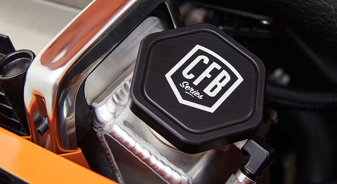 Close-up of black hexagonal cap with white CFB Series logo on metal surface