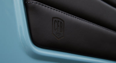 Leather panel branding embossed with CFB logo on light blue door frame of Classic Ford Bronco.