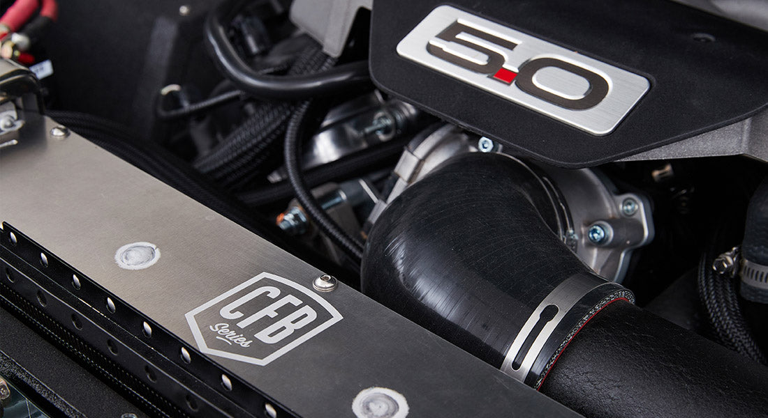 5.0 emblem on engine cover with surrounding hoses and engine components in Classic Ford Bronco