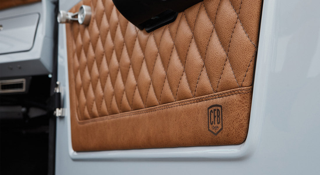 Quilted brown leather door panel with embossed CFB logo inside a Classic Ford Bronco